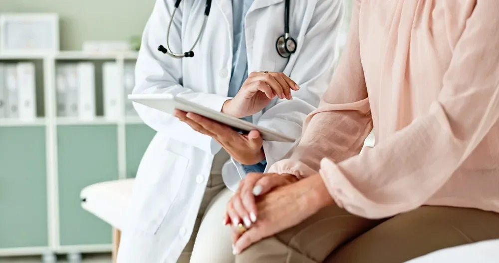 Doctor with a tablet beside a seated patient