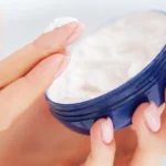 woman hand applies cream from bluejar - Is Aquaphor Good for Eczema? Benefits, Uses, and What You Should Know